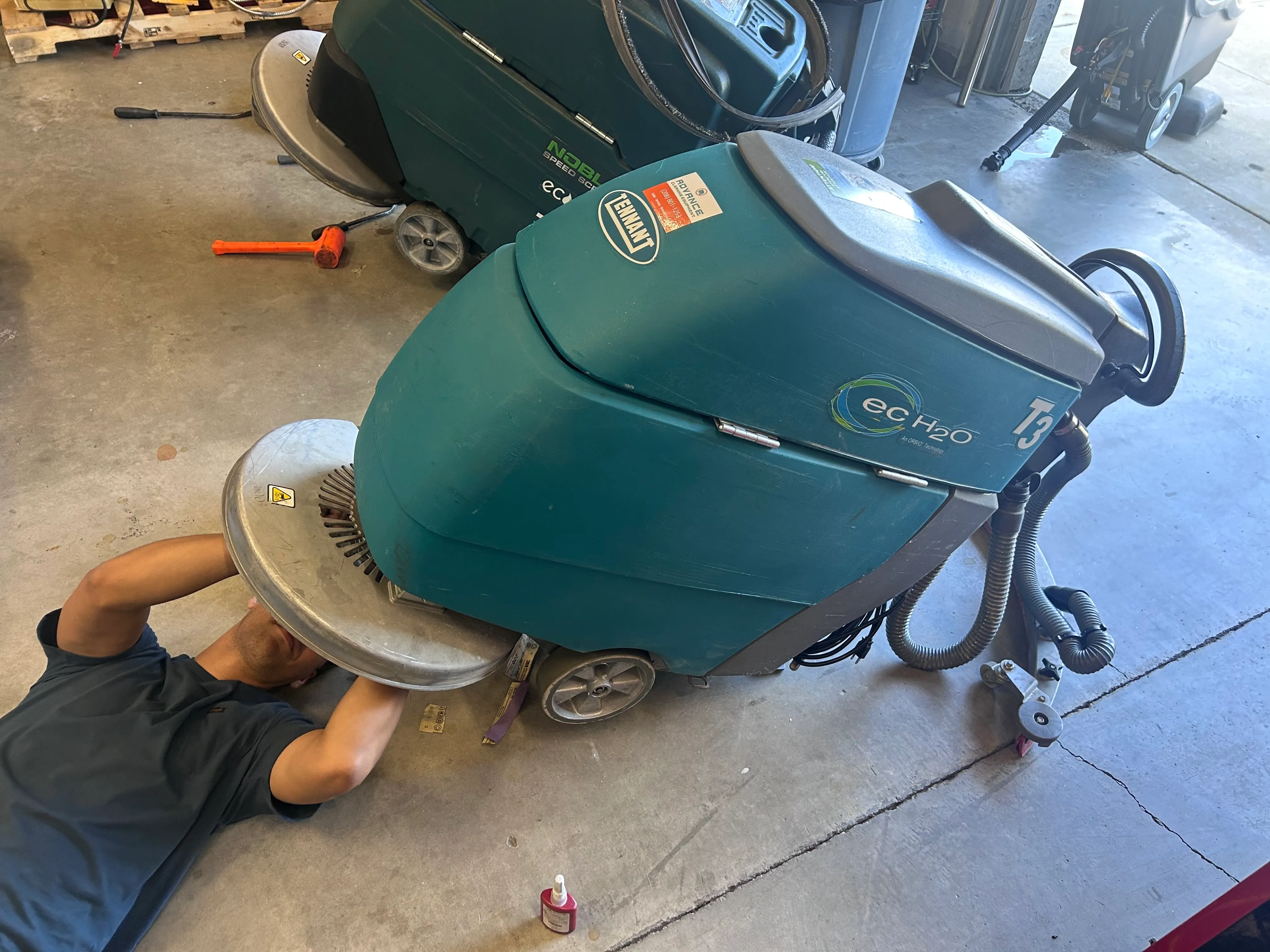 Two ACE technicians joking around in the Boise shop with a CleanMax Pro-Series upright vacuum