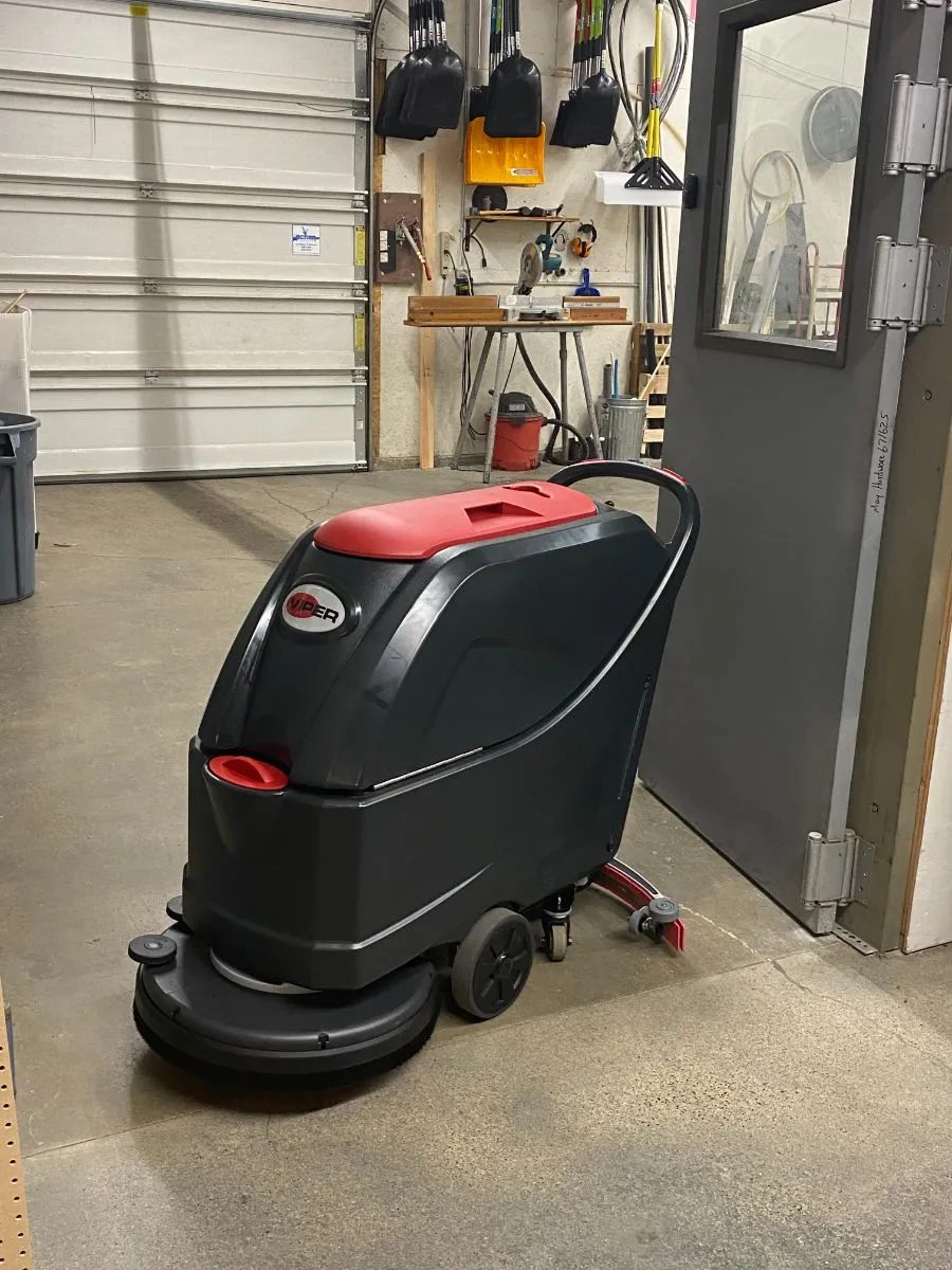 Powr-Flite walk-behind scrubber cleaning a commercial hallway